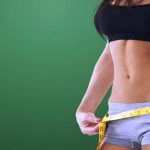 Cinta métrica midiendo la cintura de una atleta expresión de pérdida de peso al utilizar chitosán