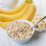 25057874 – bowl of oat flakes with sliced banana close-up on wooden table
