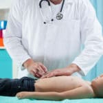34249623 – image of pediatrician doing abdominal examination